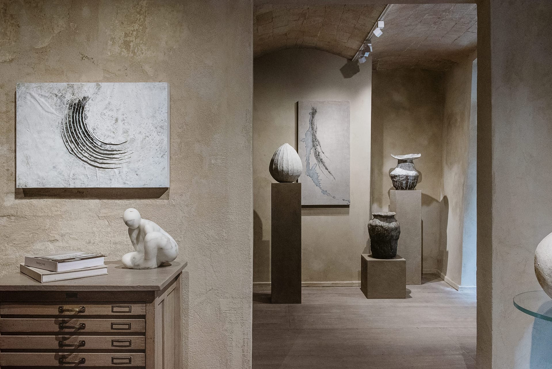 Fine-grained clay finishing plaster TerraVista Smooth Panna (cream) color and coarse-grained raw earth plaster MultiTerra Wabi Polvere and Sale Grigio (dust and gray salt) colors, all applied to the walls of Kalpa Art Gallery in the Bonomini palace in Volterra. Project by Olga Niescier, Photography by Simone Stanislai, courtesy of Kalpa